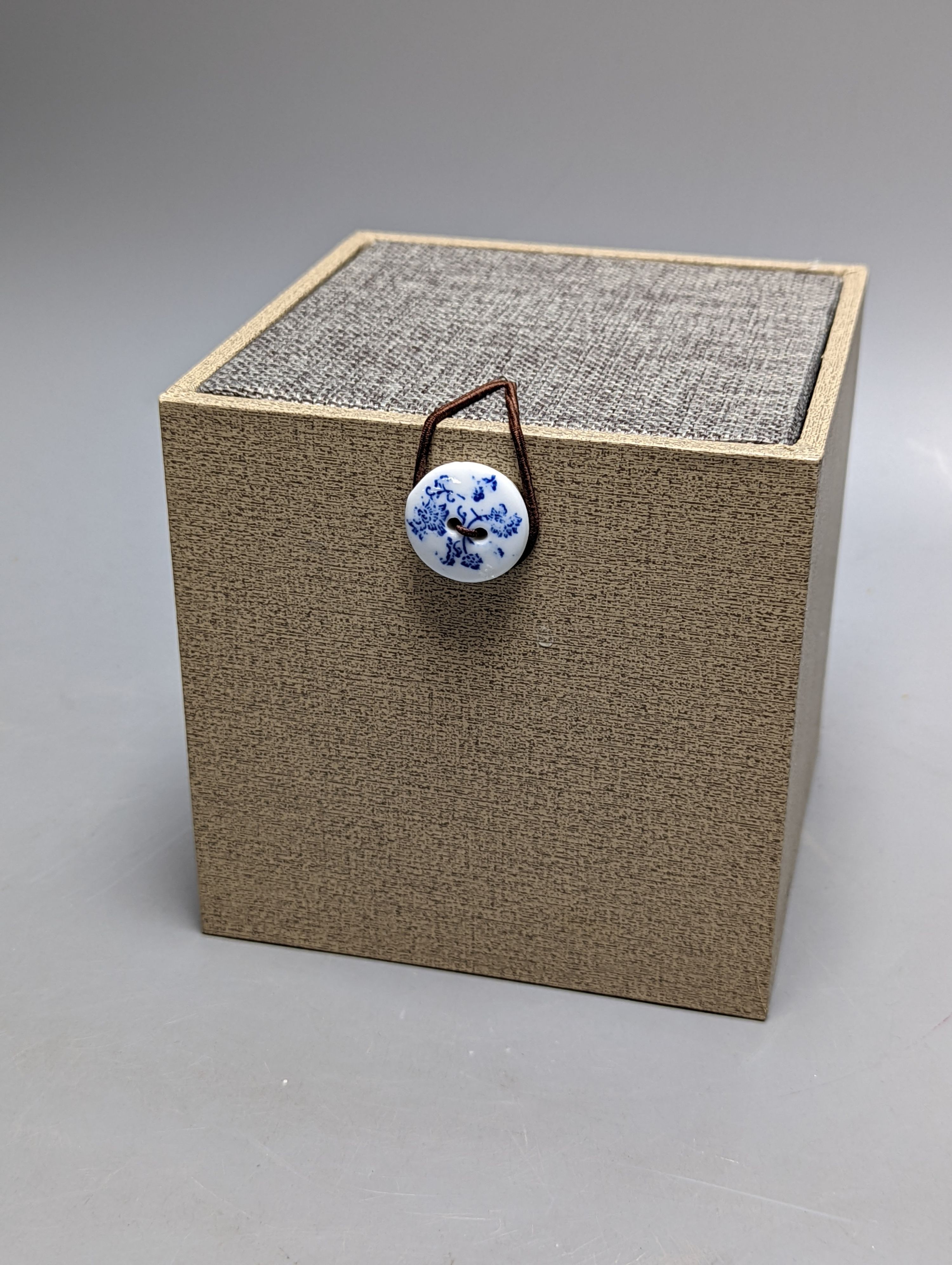 A Japanese or Chinese sgrafitto blue enamelled cup, cased. 6cm diameter